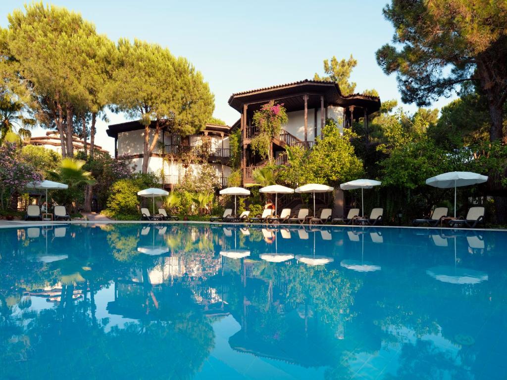 Selectum Family Resort Belek baseins ar saulessargiem un kokiem