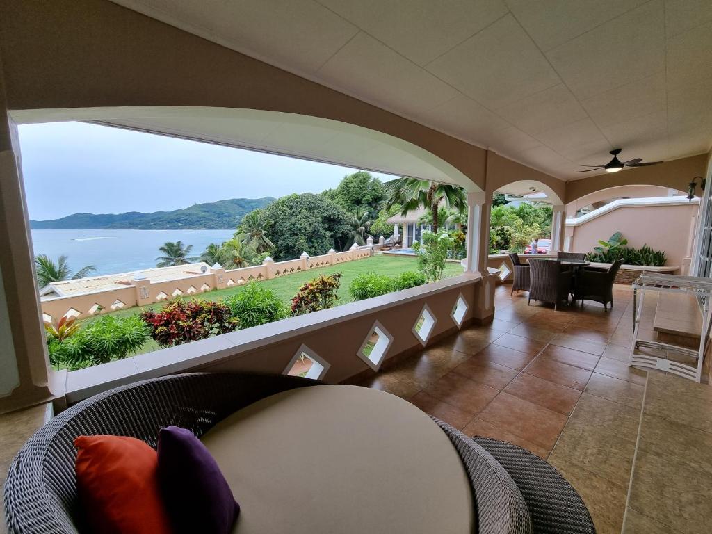 Terase ar ērtām mēbelēm un skatu uz jūru, apkārtne ar zaļām palmu un zāliena ainavām. Ideāla vieta relaksācijai un atpūtai.