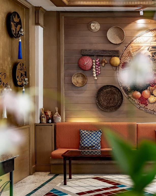 Interjera dizains ar siltām krāsām un etniskām dekorācijām, ieskaitot grozus un rotājumus uz sienas, kas rada viesmīlīgu atmosfēru. Sēdvieta ar spilgti oranžiem spilveniem un rakstainu segu papildina telpas estētiku.