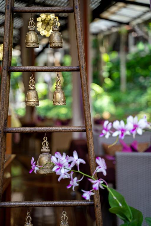 Koka kāpnes ar zeltītām zvaniņām un ziediem, radot mierīgu un estētisku atmosfēru.