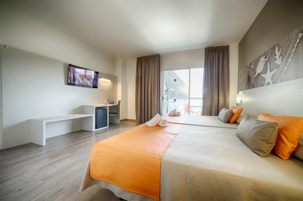 Moderns viesnīcas numurs ar divām gultām, televizoru un rakstāmgaldu, kas atrodas pie loga. Numurā ir gaišas krāsas un komfortabli spilveni.