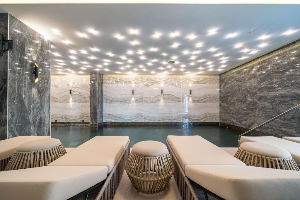 Mūsdienīgs spa interjers ar marmora sienām un elegantiem atpūtas krēsliem, apgaismots ar mirdzošām gaismām. Ideāla vieta relaksācijai un atpūtai.