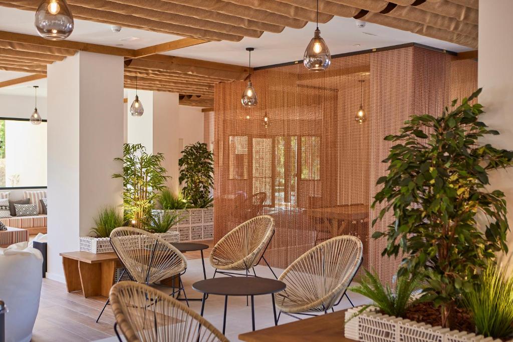 Mūsdienīgs interjers ar acij tīkamu dizainu, iekārtots ar ērtām krēsliem un zaļām augu kompozīcijām. Gaismas elementi un siltas krāsas rada patīkamu atmosfēru.