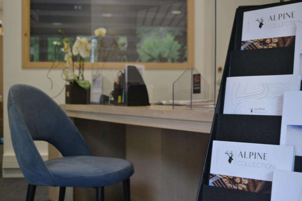 Mūsdienīgs interjers ar zilu krēslu un informācijas stendu, kas satur materiālus par "Alpine Collection". Fons ar augiem un dekoratīviem elementiem.