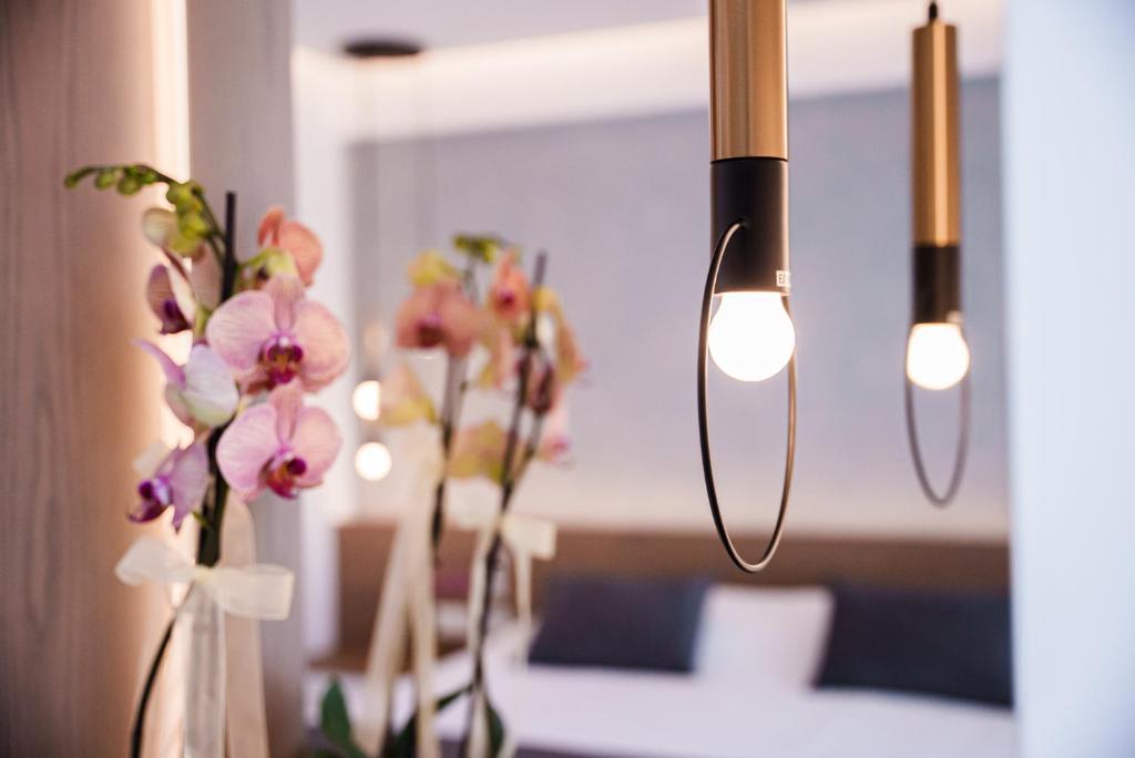 Moderns interjers ar ziediem un elegantiem gaismekļiem, radot siltu un viesmīlīgu atmosfēru.