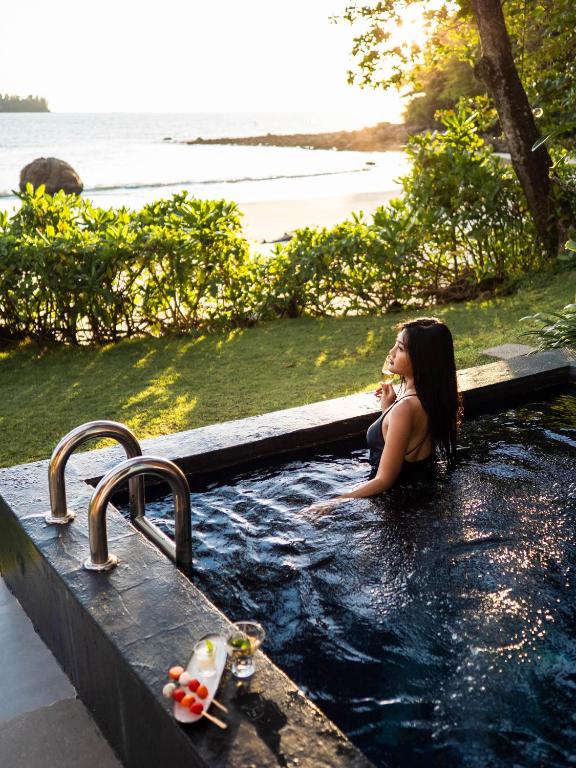 Sieviete baseinā ar skatu uz pludmali Novotel Phuket Kamala Beach