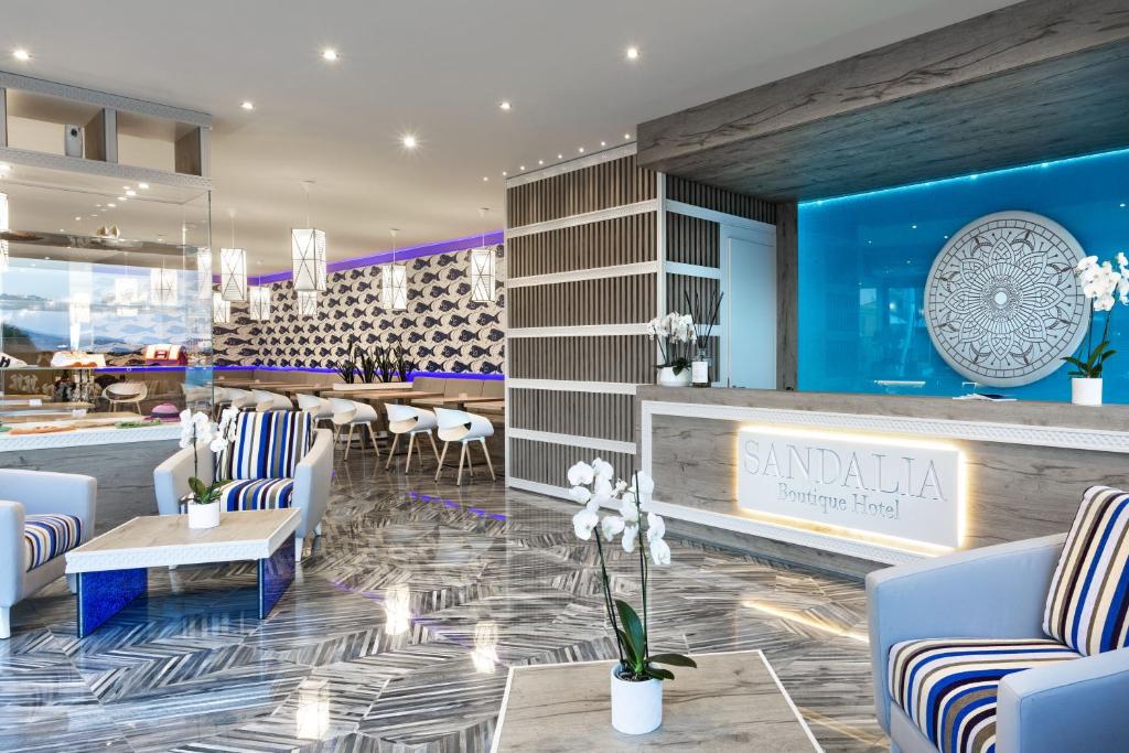 Mūsdienīgs viesnīcas iekšējais interjers ar elegantām mēbelēm un stilīgu apgaismojumu. Šeit redzama viesnīcas reģistratūra ar ziediem un modernu dizainu.