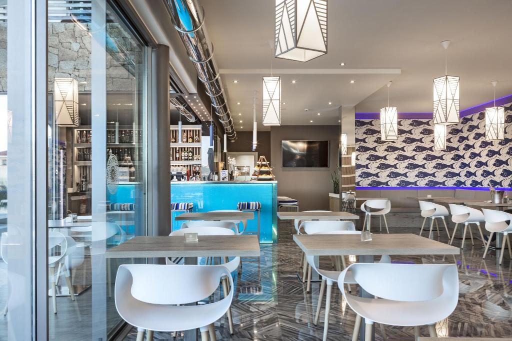 Moderns restorāns ar gaišām interjera detaļām un zilu bāru, kas izceļas ar stilīgu apgaismojumu un mūsdienīgu dizainu. Atvērtā telpa rada patīkamu atmosfēru, ideālu maltītēm un atpūtai.