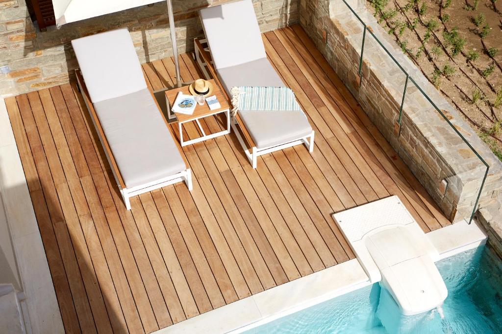 Atpūtas zona ar divām saulessargiem, galdu un peldbaseinu, radot ideālu vidi relaksācijai un atpūtai. Svaiga un moderna atmosfēra ar koka terasi.