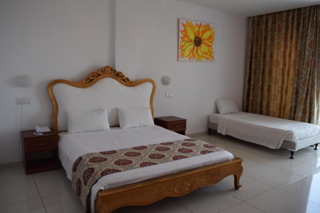 Mūsdienīgs viesnīcas numurs ar elegantu gultu un gaišu interjeru, papildināts ar mākslas darbu un mīkstām aizkariem. Ideāla vieta relaksācijai un atpūtai.