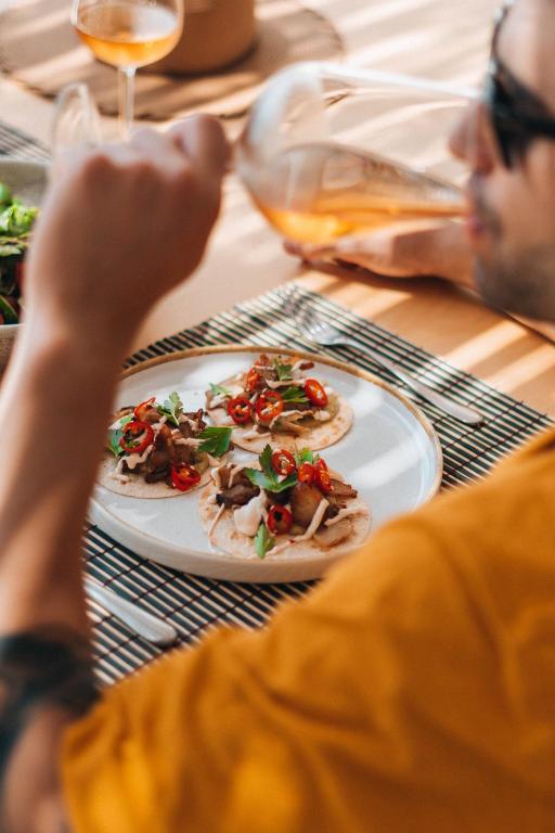 Garšīgi tacos ar gaļu, zaļumiem un sarkaniem pipariem, ko pasniedz pie vīna glāzes. Ideāla brīvdienu maltīte.