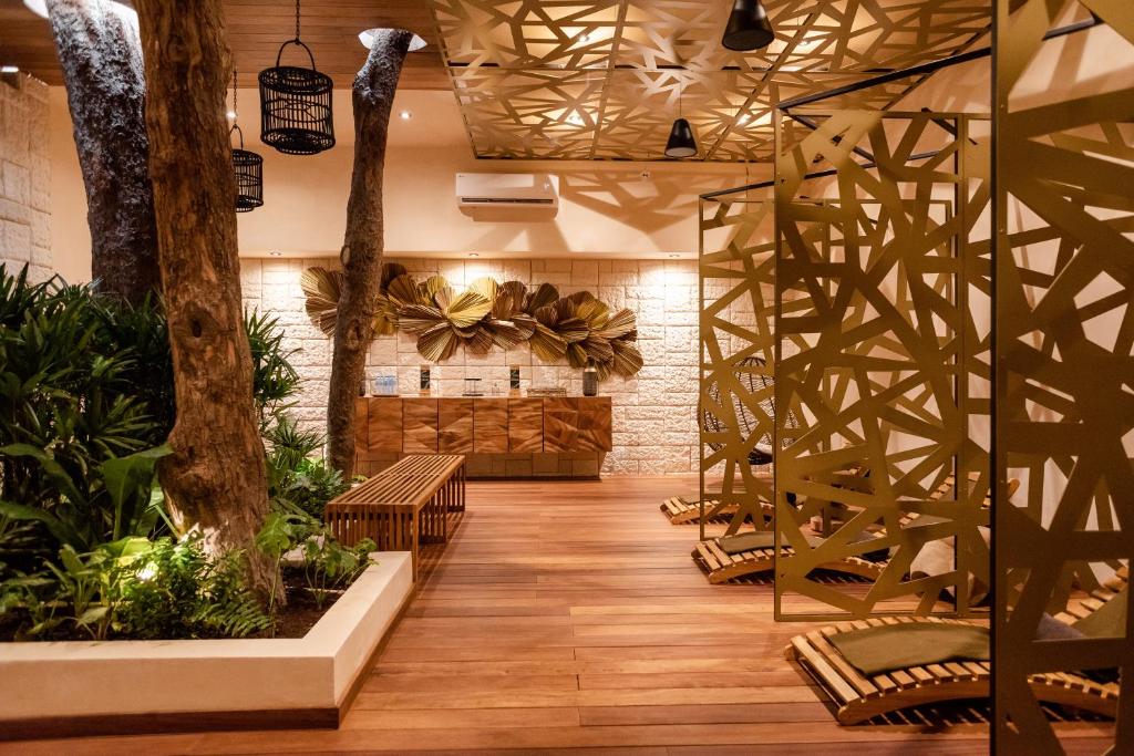 Mūsdienīgs interjers ar dabīgām koka elementiem un zaļiem augiem, radot relaksējošu atmosfēru. Telpā ir izsmalcināti dekoratīvi akcenti un komfortablas atpūtas zonas.