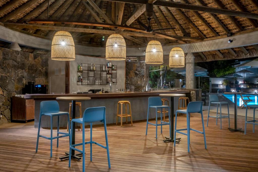 Moderns bārs ar koka griestiem un ratiņiem, apgaismots ar stilīgām lampām. Kafejnīca atrodas pie baseina un piedāvā relaksējošu atmosfēru.
