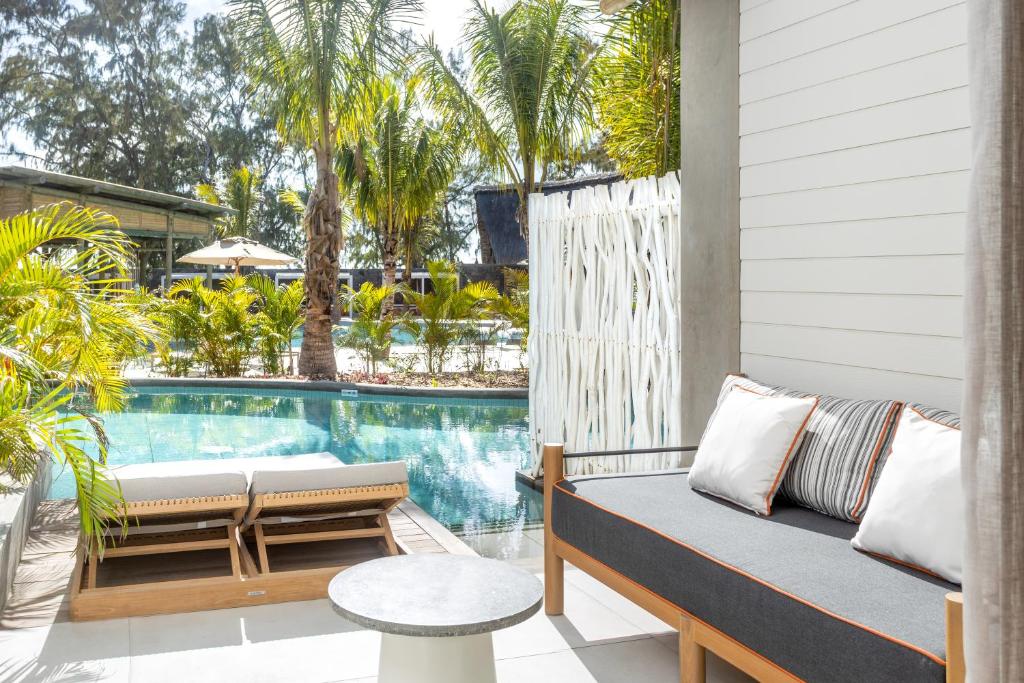 Mūsdienīgs atpūtas stūris ar skatu uz peldbaseinu, apkārt palmām un zaļumiem, kas rada relaksējošu atmosfēru. Ideāla vieta atpūtai un baudīšanai.