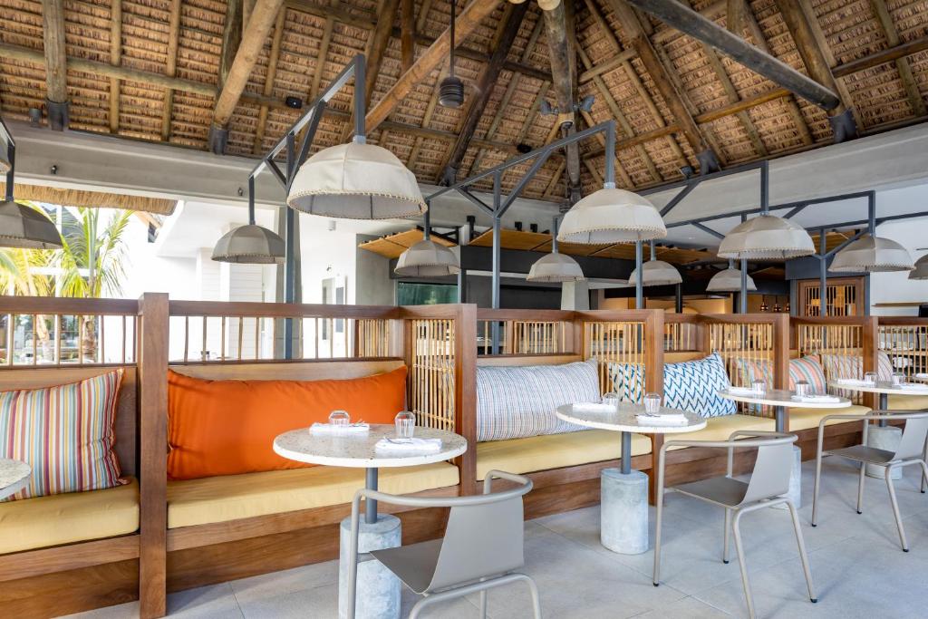 Mūsdienīgs restorāna interjers ar koka elementi, krāsainām spilveniem un stilīgām lampām, radot patīkamu atmosfēru. Ideāla vieta relaksācijai un baudīšanai.