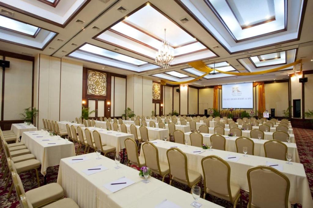 Konferenču zāle ar elegantiem galdiem un krēsliem, gatava pasākumam. Interjers ar modernu apgaismojumu un greznu dekoru.