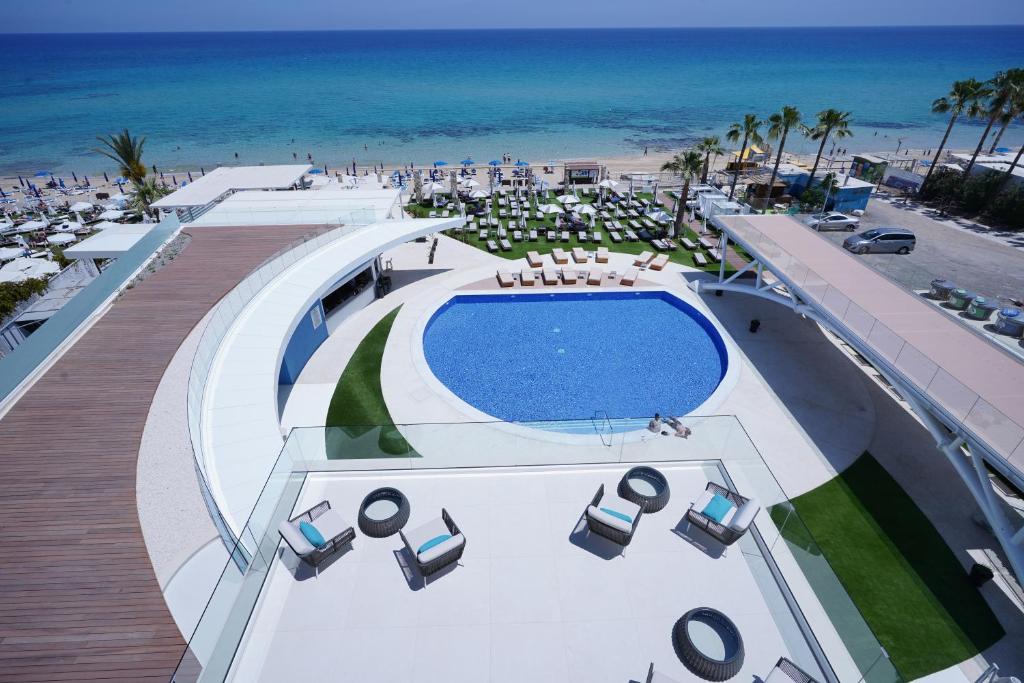 Mūsdienīgs viesnīcas komplekss ar baseinu un atpūtas zonu, kas piedāvā skatu uz pludmali un jūru. Apkārt baseinam ir sauļošanās krēsli un zaļās zonas, radot relaksējošu atmosfēru.