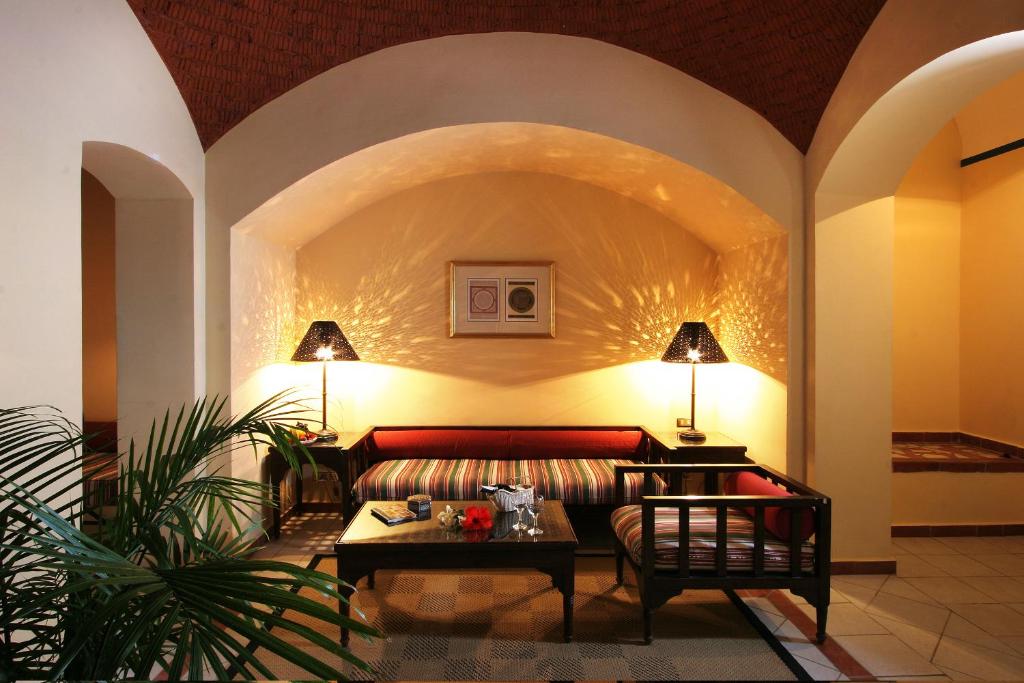 Mūsdienīgs viesnīcas uzgaidāmā telpa ar komfortablu dīvānu, elegantu lampu un mājīgu atmosfēru. Telpā ir siltas krāsas un dekoratīvi elementi, kas rada relaksējošu vidi.