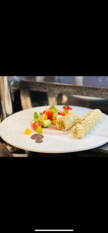 Plāksnē ir elegantas desertu kompozīcijas, kurās ietilpst augļu un riekstu ruletītes, kā arī svaigi augļi, piemēram, zemenes un ķirši, pievienoti dekoratīvā izkārtojumā.