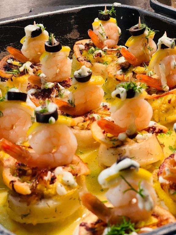 Garnelēm rotāti uzkodu šķīvji ar citronu un olīvu, dekorēti ar dilles lapām. Ideāla izvēle svinībām vai svētku galdam.