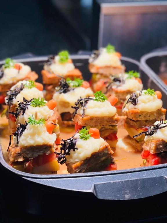 Gards un krāsains ēdiens, kas sastāv no slāņotiem dārzeņiem un gaļas, pārklāts ar kartupeļu biezeni un rotāts ar zaļumiem. Ideāls priekšstats par izsmalcinātu kulināriju.