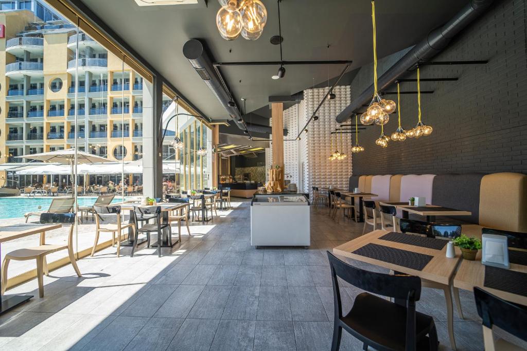 Mūsdienīgs restorāns ar stikla sienām, kas vērstas uz baseinu, piedāvā elegantu interjeru ar stilīgām lampām un koka mēbelēm. Ideāla vieta relaksācijai un izsmalcinātām maltītēm.