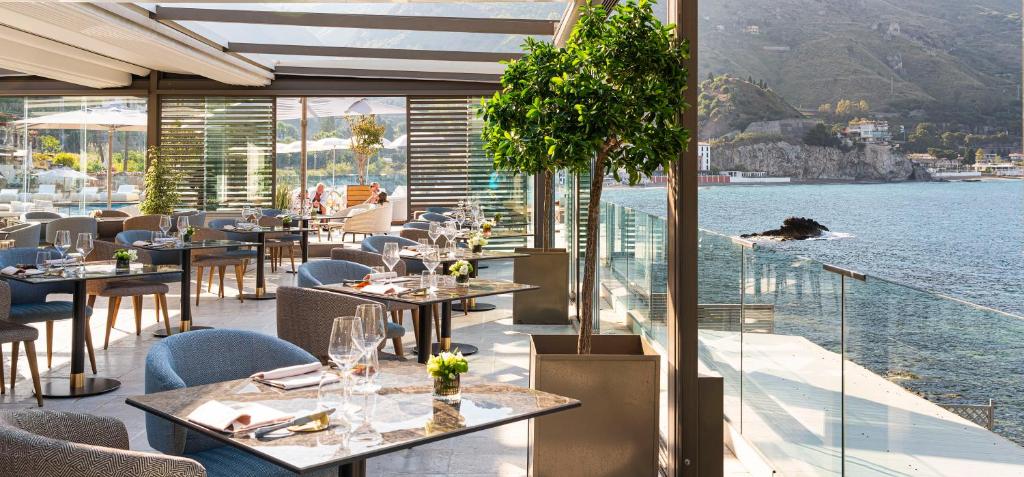 Elegants restorāns ar skatu uz jūru, kur interjers ir izsmalcināts un moderns, ar elegantiem galdiem un komfortablām mēbelēm. Ideāla vieta romantiskām vakariņām vai relaksējošām pusdienām.