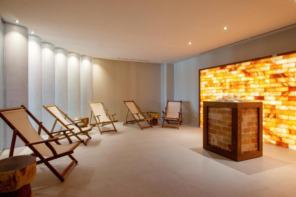 Mūsdienīgs spa telpa ar ērtām atpūtas krēsliem un siltu sāls sienu, radot relaksējošu atmosfēru. Ideāli piemērota atpūtai un labsajūtai.
