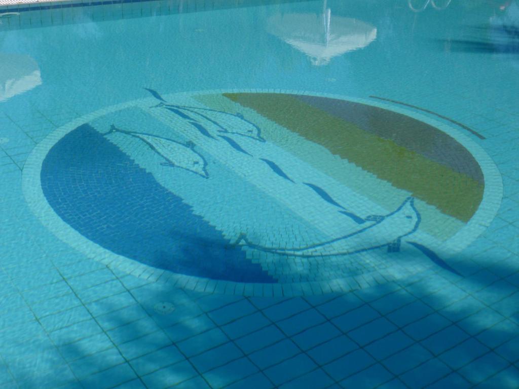 Baseina mozaīka ar delfīniem un krāsainām svītrām, kas atspoguļo ūdens relaksējošo atmosfēru.