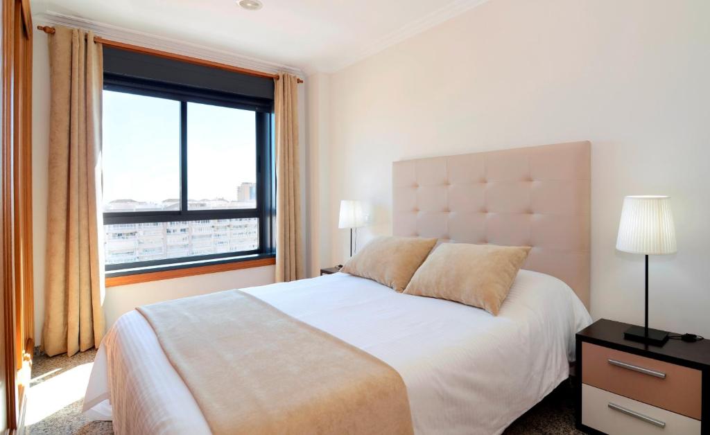 Mūsdienīga guļamistaba ar lielu logu, kas ļauj ieplūst dabīgai gaismai, un ērtu gultu ar spilveniem. Interjers ir vienkāršs un elegants, ar gaismas ķermeņiem un minimālistisku dizainu.