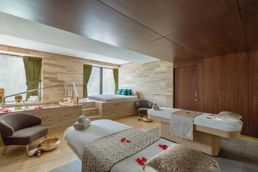 Mūsdienīga spa telpa ar masāžas galdiem, relaksējošu atmosfēru un dabas elementiem, piemērota atpūtai un relaksācijai.