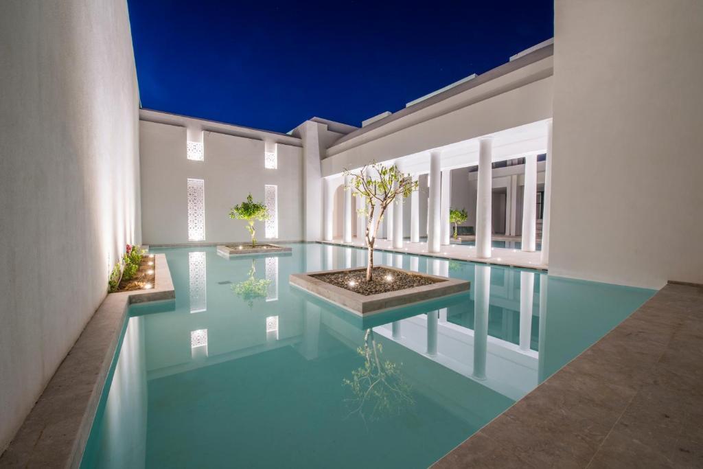 Moderns arhitektūras elements ar ūdenskrāsu dīķi, apgaismotu terasi un augiem, kas rada mierīgu atmosfēru. Ideāla vieta relaksācijai un meditācijai.