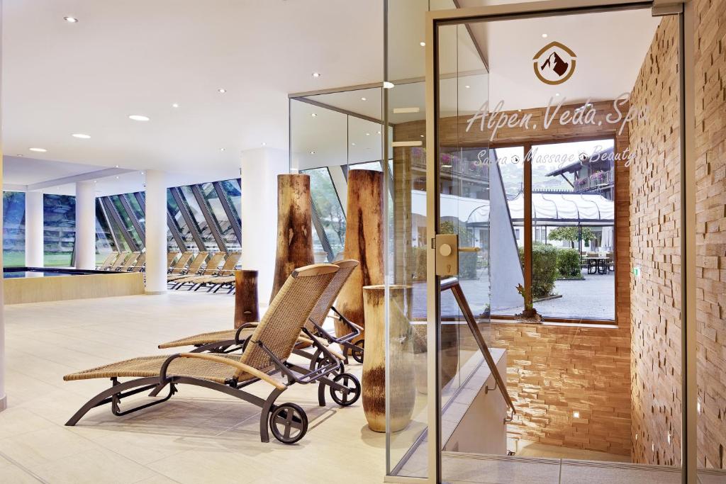 Eleganta spa iekārta ar modernu dizainu, kurā redzamas atpūtas krēsli un lieli logi, kas ļauj iekļūt dabai. Spa piedāvā masāžas un skaistumkopšanas procedūras.