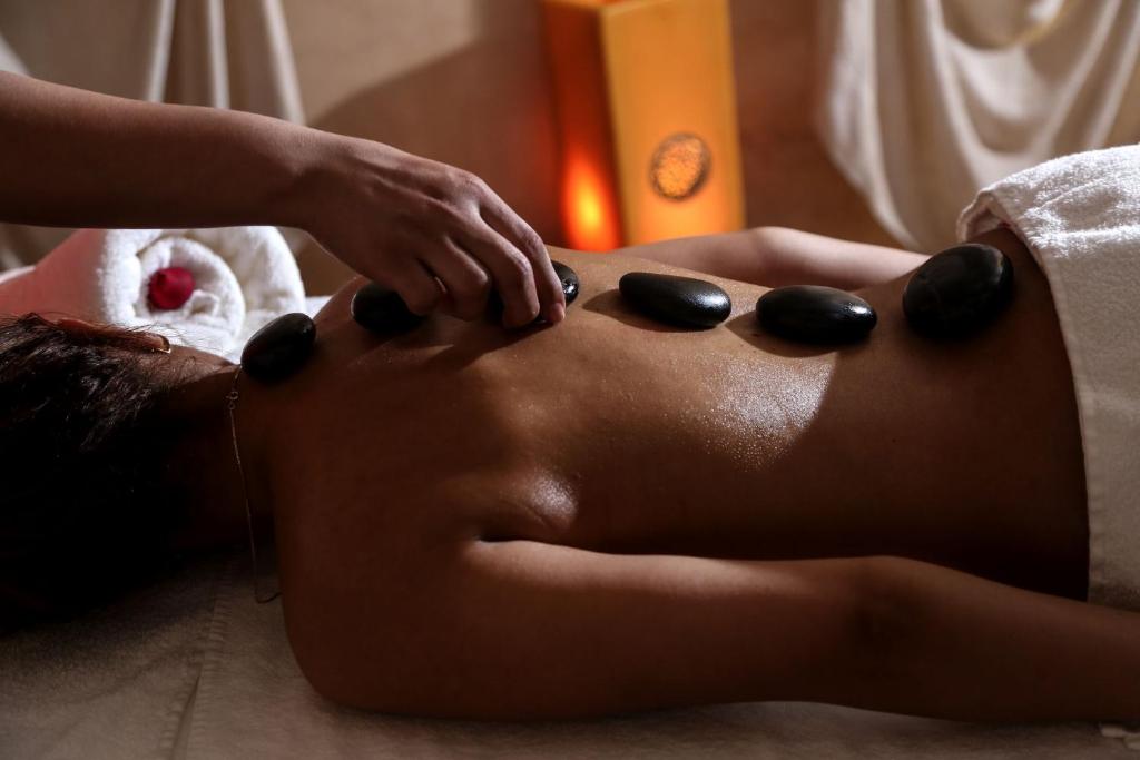 Masažas ar karstām akmeņiem, kur masieris uzklāj akmeņus uz klienta muguras relaksējošā vidē.