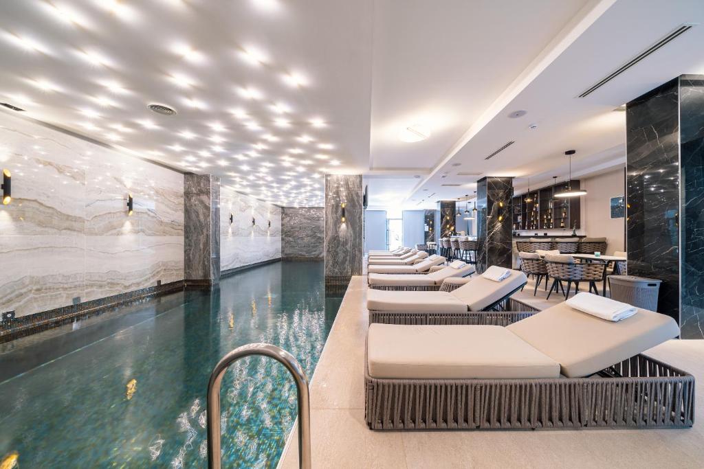 Mūsdienīgs spa ar baseinu, atpūtas krēsliem un elegantiem interjera elementiem, radot relaksējošu atmosfēru. Ideāla vieta atpūtai un relaksācijai.