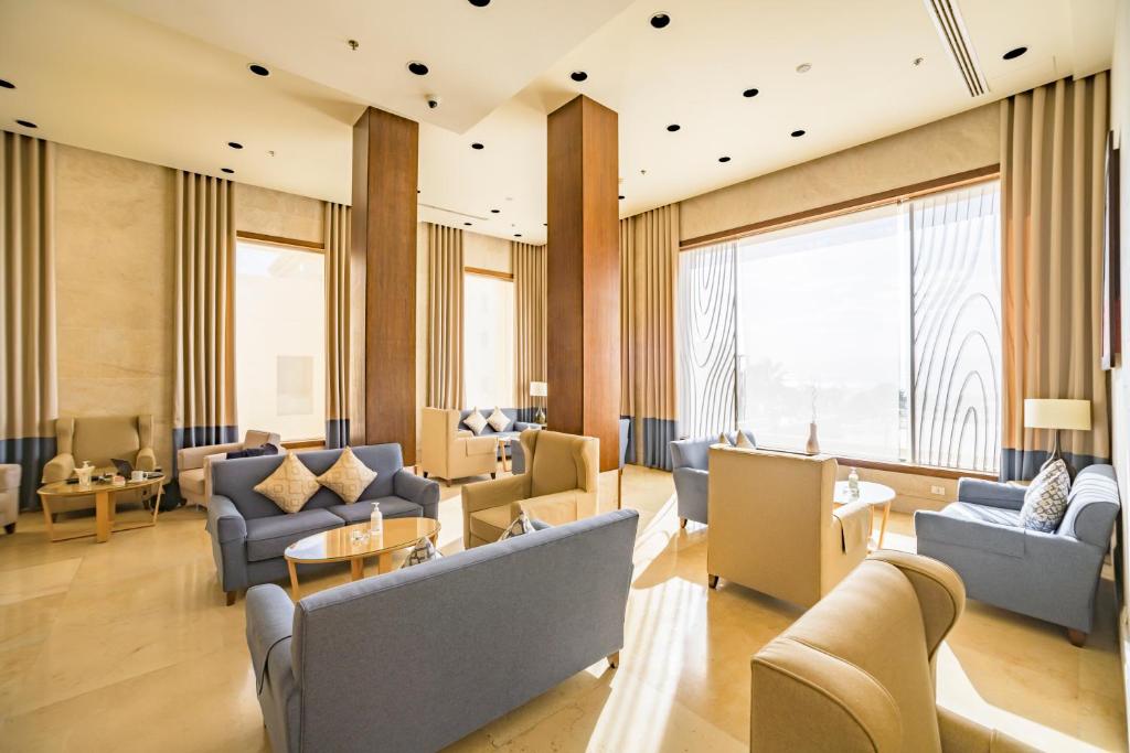 Elegants un gaišs viesnīcas salons ar modernu interjeru, kurā ir komfortabli dīvāni un lieli logi, kas nodrošina dabīgu apgaismojumu. Ideāli piemērots atpūtai vai neformālām tikšanām.