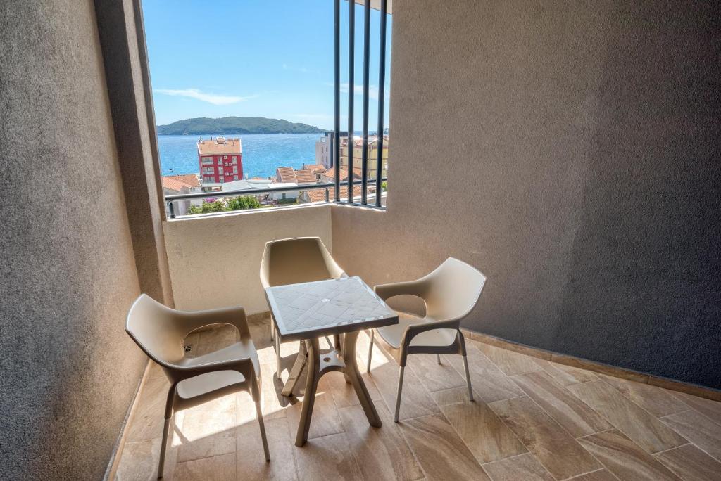 Balkons ar skatu uz jūru, kurā ir divi krēsli un galds, izveidojot relaksējošu atmosfēru. Ideāli piemērots atpūtai un baudīšanai.