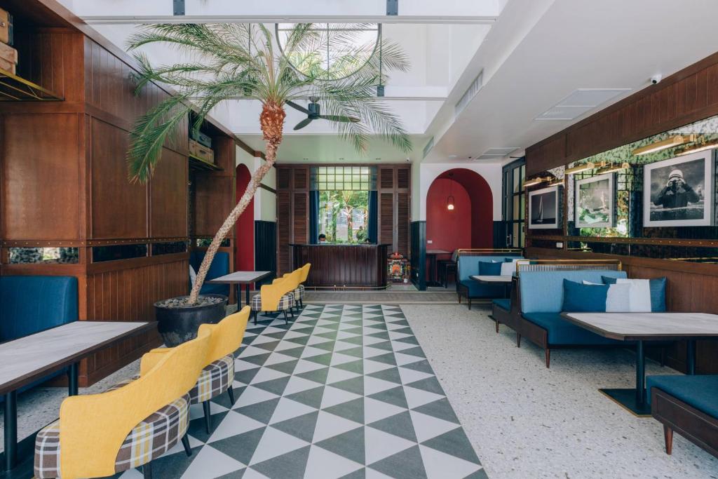 Moderns interjers Sugar Marina Nautical viesnīcā ar palmām un dekoratīvām fotogrāfijām.