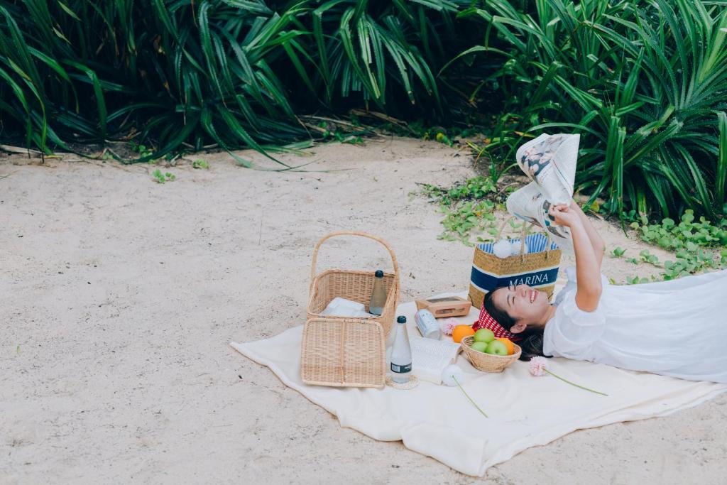 Sieviete atpūšas pludmalē ar piknika grozu Sugar Marina Nautical