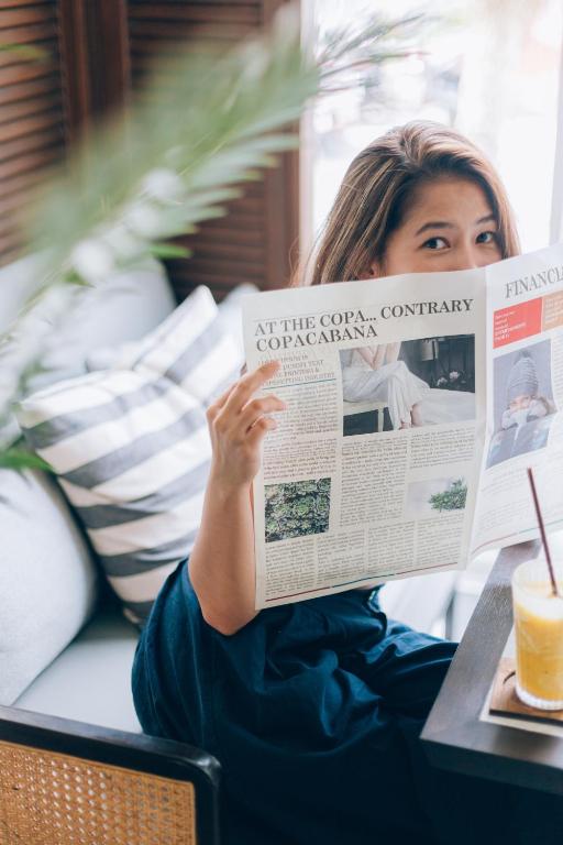 Sieviete, kas lasa avīzi viesnīcā Sugar Marina Nautical.