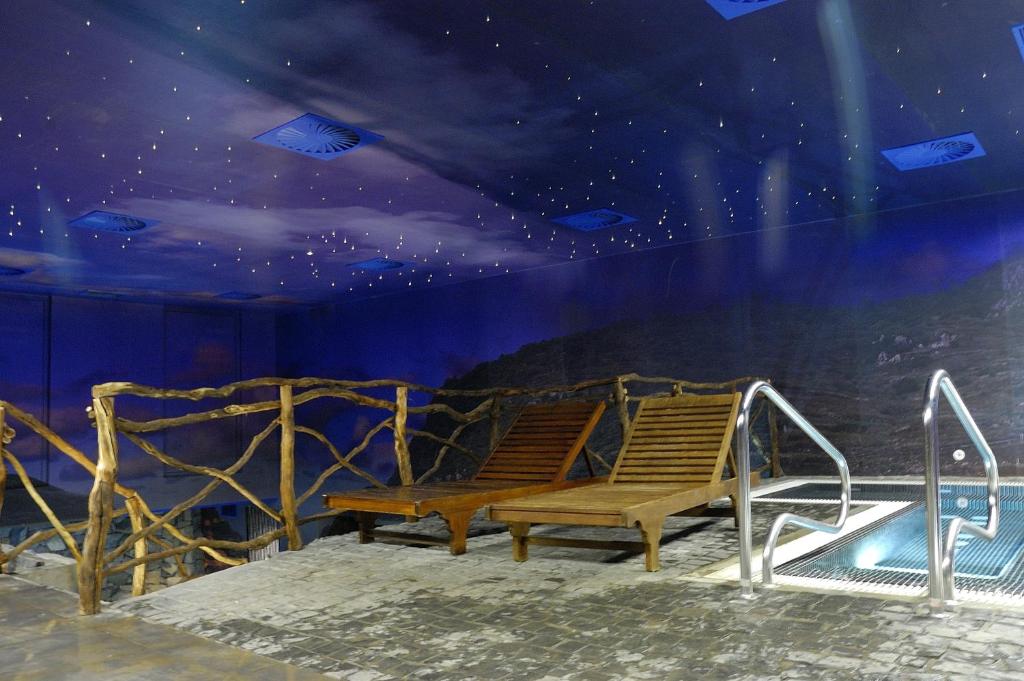 Mūsdienīgs spa telpa ar koka atpūtas krēsliem un relaksējošu zilu griestu apgaismojumu, kas imitē zvaigžņotu debesi. Vasaras atmosfēra un mierīga vide.