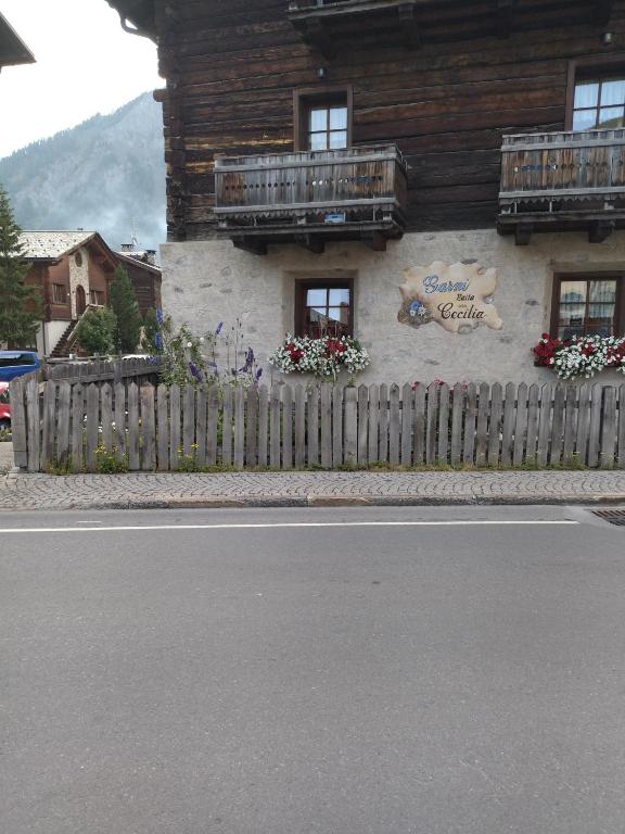 Vietējā viesnīca ar ziediem pie logiem un koka žogu, atrodas kalnu apvidū. Ēka ir tradicionālā alpu stilā ar koka apdari.