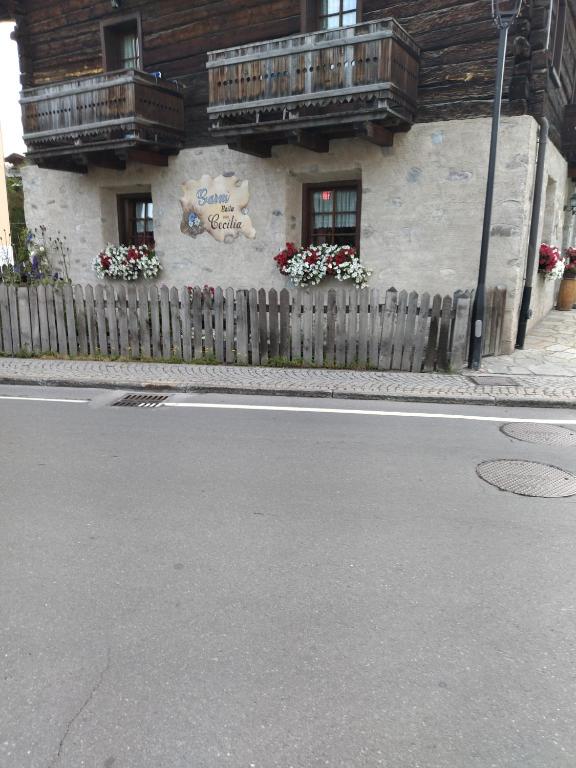 Šī ir gleznaina māja ar tradicionālu arhitektūru, kurā ir balkoni un ziedu puķes pie logiem. Mājai ir akmens un koka fasāde, un tā atrodas netālu no ielas.