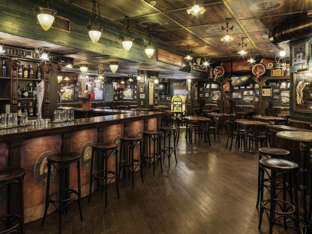 Vietējā bāra interjers ar koka grīdu, garu bāra leti un koka krēsliem, rotāts ar vintage plakātiem un retro jukebox. Atmosfēra ir silta un aicinoša, ideāli piemērota kopā sanākšanai.