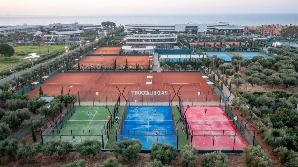 Tenisa laukumi ar dažādām spēļu platēm un skatu uz jūru, kas veido lielisku sporta un atpūtas atmosfēru.