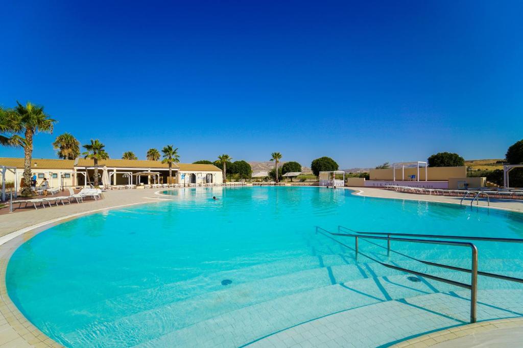 Liela peldbaseina ar skaidru ūdeni un saulainu debesi, apkārt palmām un atpūtas zonām. Ideāla vieta relaksācijai un izklaidei.