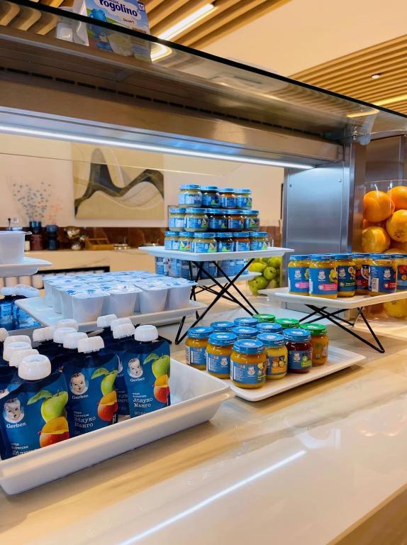 Bērnu pārtikas un dzērienu stends ar dažādiem produktiem, tostarp bērnu biezenīšiem un jogurtiem, izvietots uz eleganta galda.
