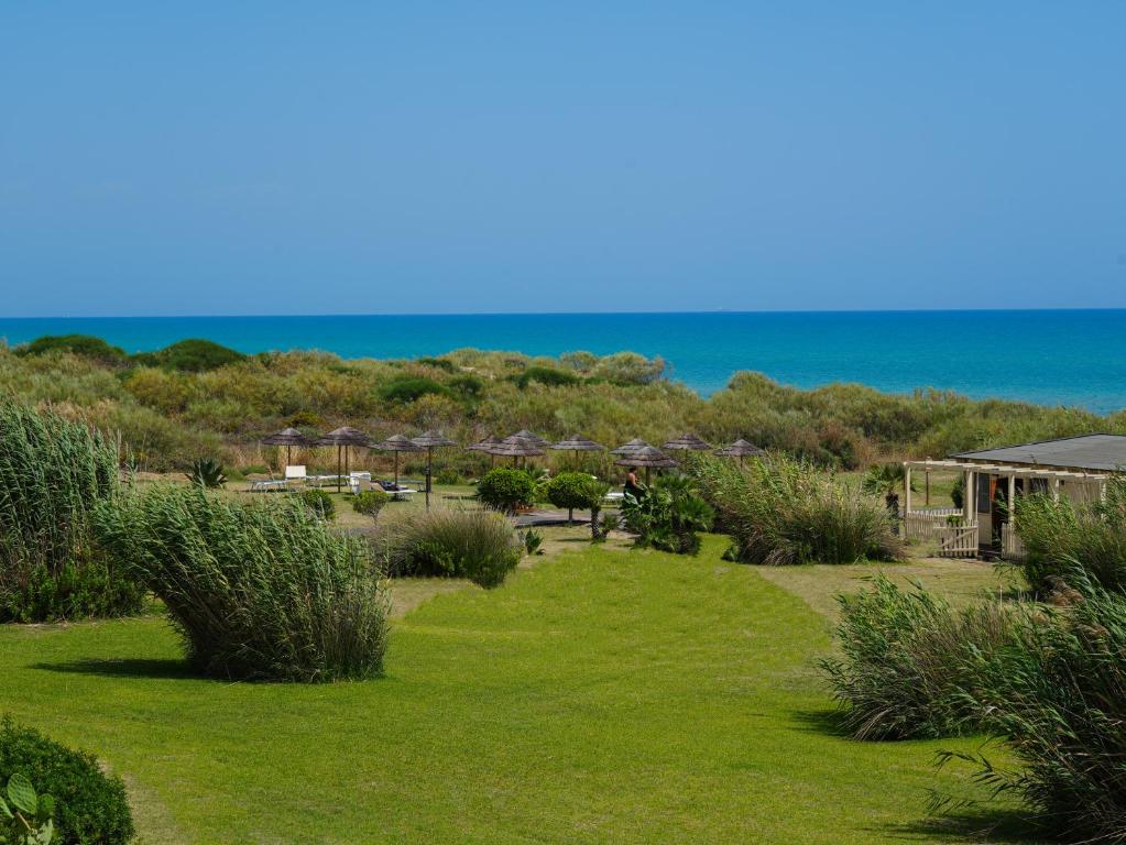 Skaista pludmale ar zaļiem zālieniem un sauļošanās vietām, kas atrodas blakus zilo jūru un krūmiem. Ideāla vieta relaksācijai un atpūtai.