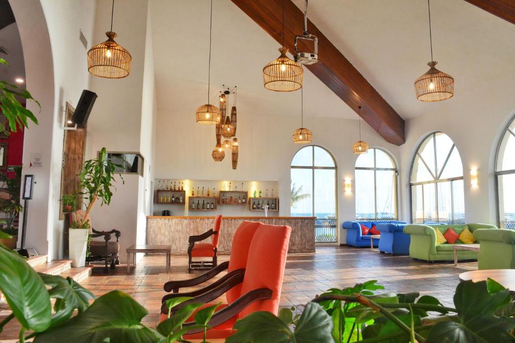 Eleganta uzņemšanas zona All Ritmo Cancun Resort & Waterpark ar krāsainiem krēsliem.