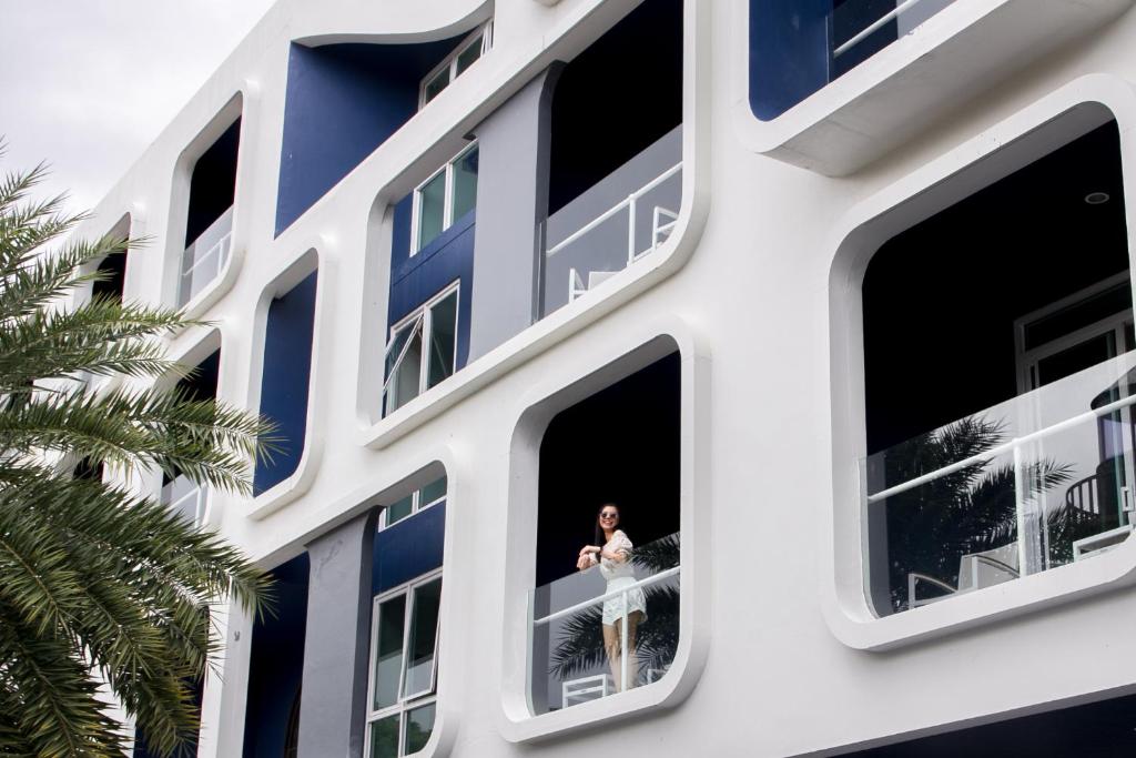 Sieviete stāv uz balkona viesnīcā Sugar Marina Nautical, modernā arhitektūrā.